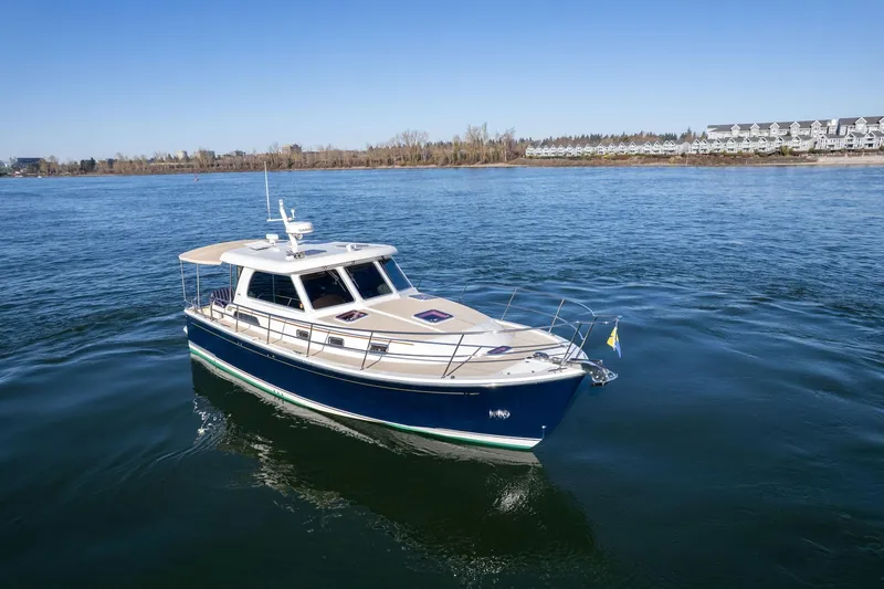 Jackson Yacht Photos Pics 2013 Sabre 38 Salon Express yacht cruising on a calm river near a residential area.