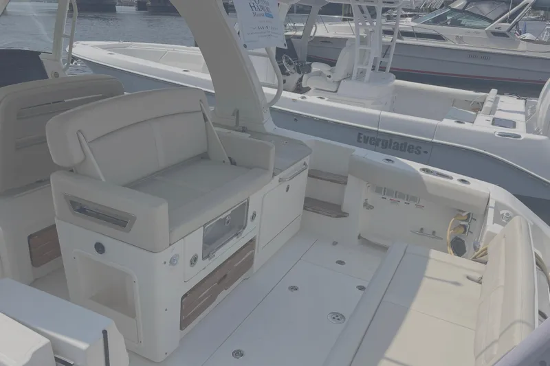  Yacht Photos Pics 2020 Boston Whaler 350 Realm boat interior with seating and storage, docked near other boats.