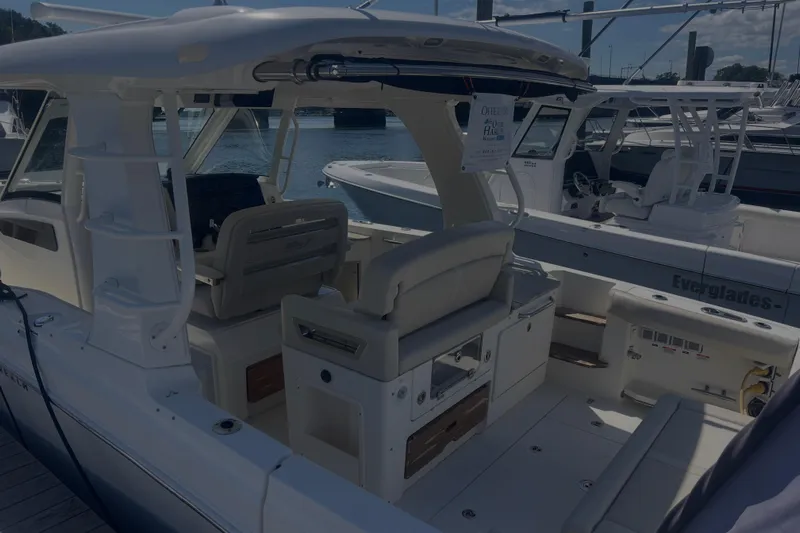  Yacht Photos Pics 2020 Boston Whaler 350 Realm boat interior at marina, showcasing seating and helm area.