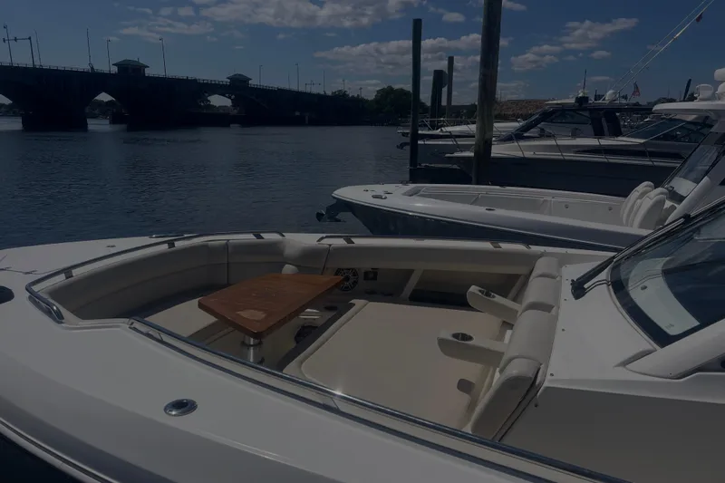  Yacht Photos Pics 2020 Boston Whaler 350 Realm docked near a bridge under a partly cloudy sky.
