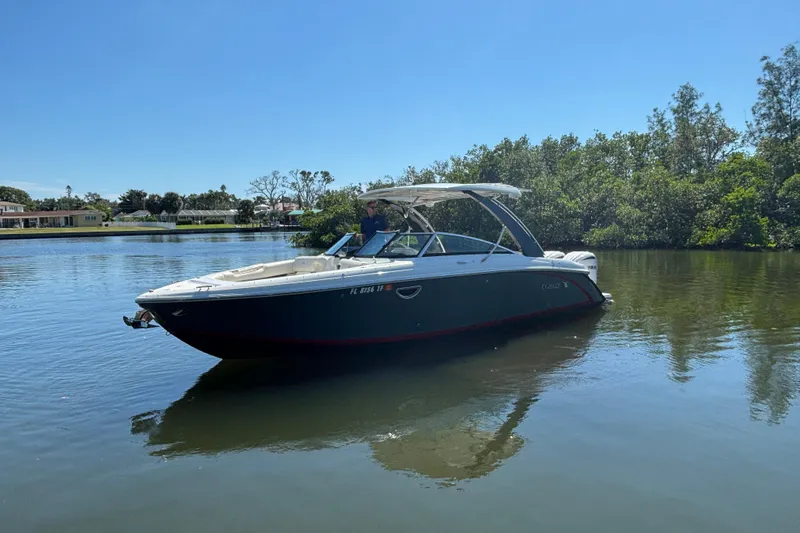  Yacht Photos Pics 2022 Cobalt 30SC boat on calm water with lush greenery background.