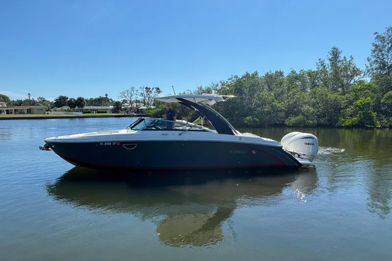  Yacht Photos Pics 2022 Cobalt 30SC boat cruising on a calm river under a clear blue sky.
