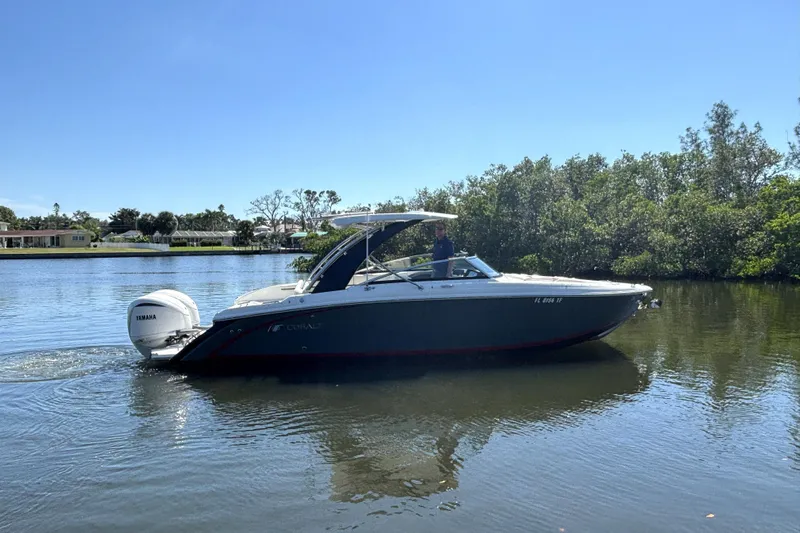  Yacht Photos Pics 2022 Cobalt 30SC boat cruising on a calm river with lush greenery.
