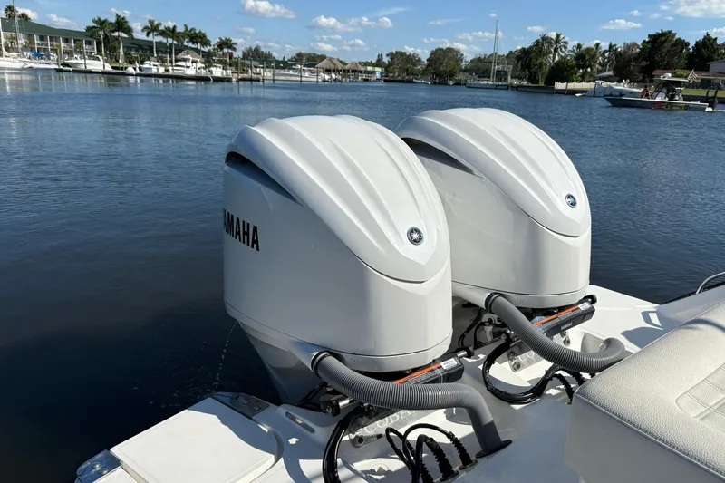  Yacht Photos Pics Twin Yamaha outboard engines on a 2022 Cobalt 30SC boat, docked by a scenic waterfront.