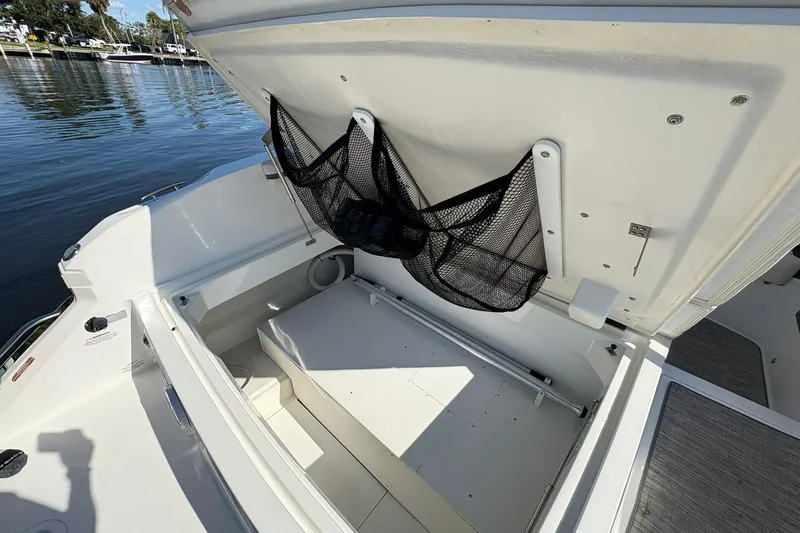  Yacht Photos Pics 2022 Cobalt 30SC boat storage compartment with mesh netting, docked by the water.