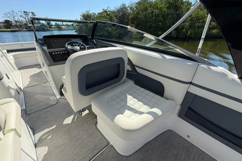  Yacht Photos Pics 2022 Cobalt 30SC boat interior with modern helm and seating, docked by lush greenery.