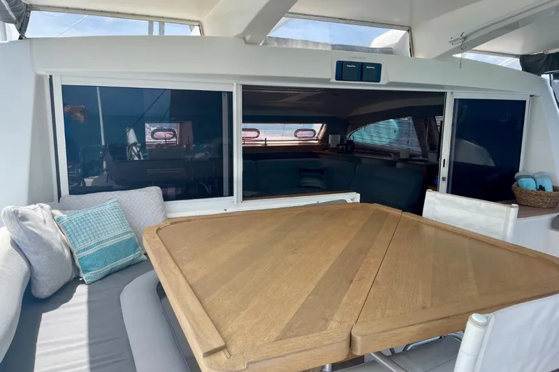 Hera Yacht Photos Pics 2008 Catana 50 yacht interior with wooden table and cushioned seating.