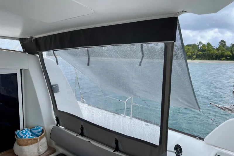 Hera Yacht Photos Pics Catana 50 yacht interior with ocean view, featuring a shaded window and tropical scenery.