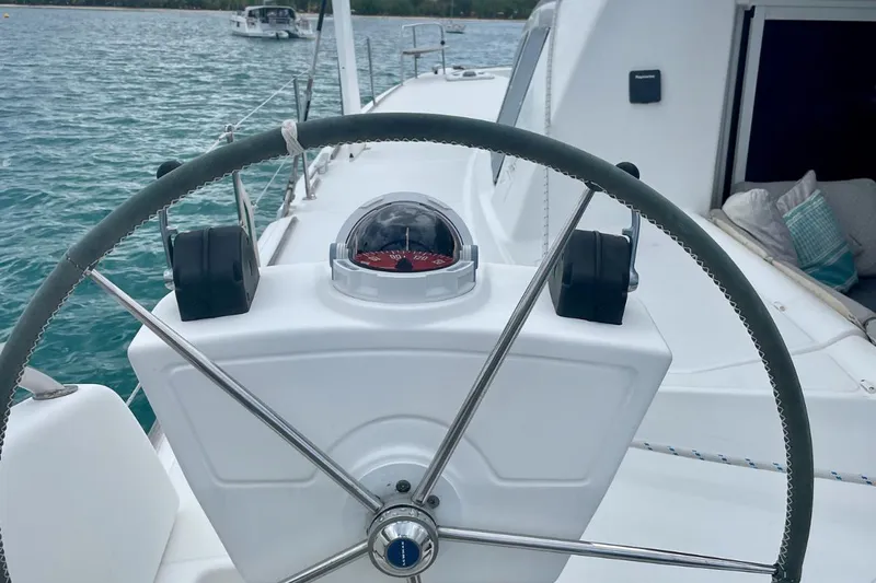 Hera Yacht Photos Pics Steering wheel of a 2008 Catana 50 catamaran with compass, on calm waters.