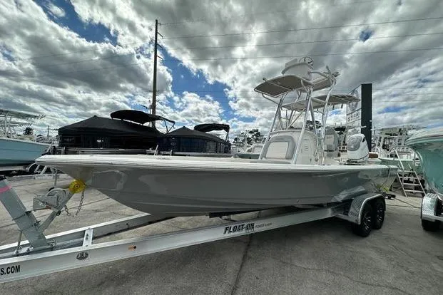 2024 Avenger AV26 boat on trailer under cloudy sky at marina.