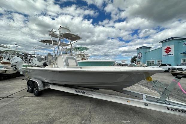 2024 Avenger AV26 boat on trailer at dealership under cloudy sky.