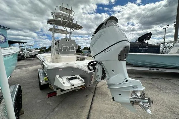 2024 Avenger AV26 boat with Suzuki outboard motor on a trailer, under cloudy sky.