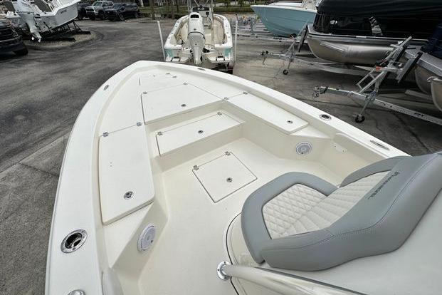 2024 Avenger AV26 boat with spacious deck and seating, displayed in a showroom.
