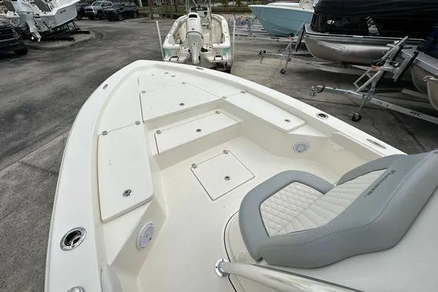 2024 Avenger AV26 boat with spacious deck and seating, displayed in a showroom.