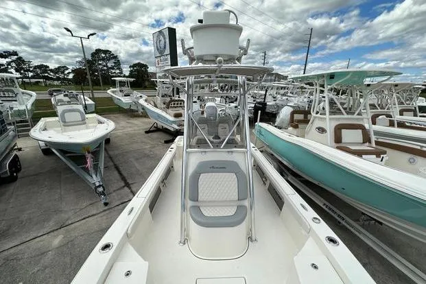 2024 Avenger AV26 boat displayed in a dealership, surrounded by other boats under a cloudy sky.