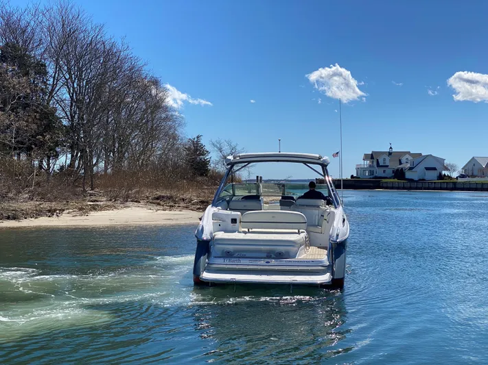  Yacht Photos Pics 2018 Cobalt R35 boat cruising near a shoreline with clear blue skies.