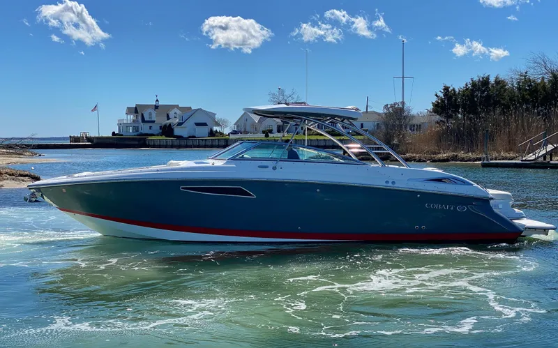  Yacht Photos Pics 2018 Cobalt R35 boat cruising on a sunny day near waterfront homes.
