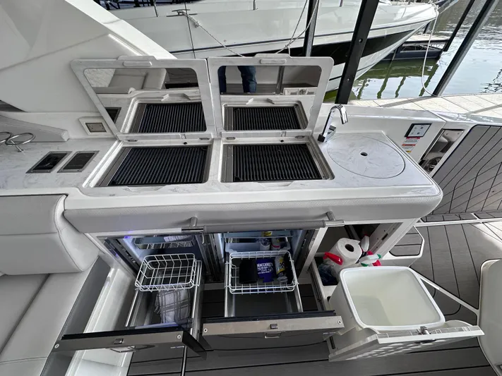  Yacht Photos Pics 2023 Sea Ray SLX 400 OB boat kitchen with grills, refrigerators, and sink.