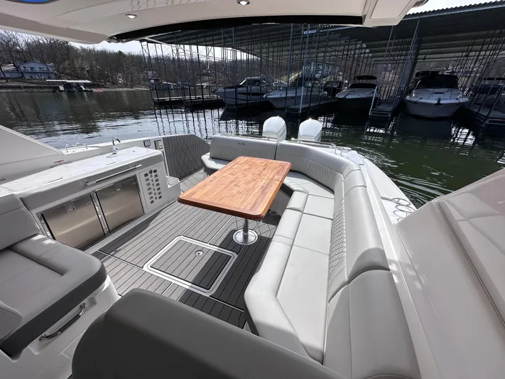  Yacht Photos Pics 2023 Sea Ray SLX 400 OB boat interior with seating and wooden table.