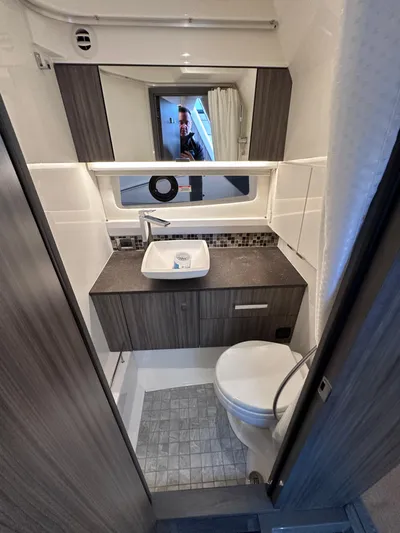  Yacht Photos Pics 2023 Sea Ray SLX 400 OB bathroom with modern sink, toilet, and mirror.