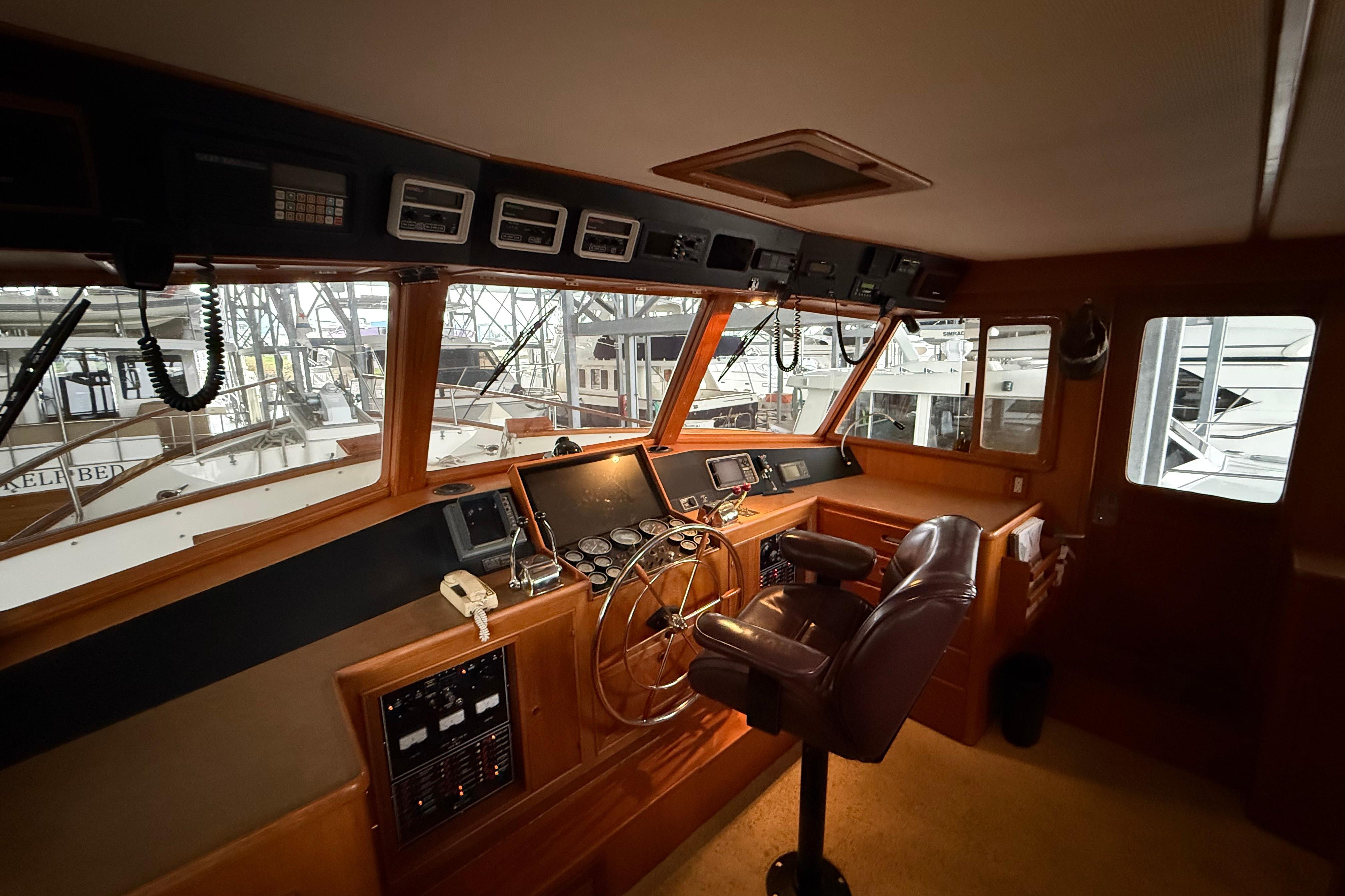 1988 Fleming Pilothouse interior with navigation controls and captain's chair.
