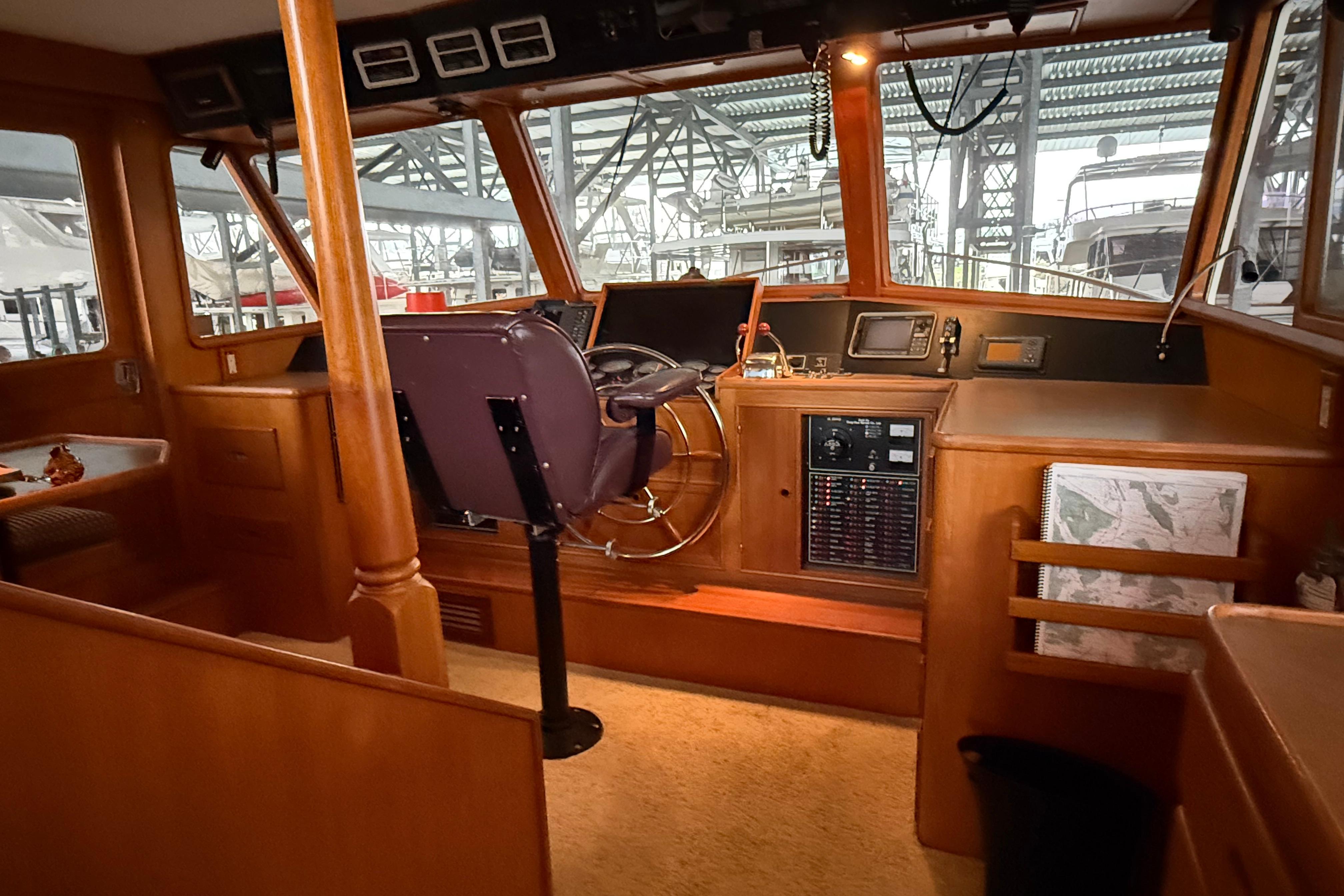 1988 Fleming Pilothouse interior with navigation equipment and wooden finish.
