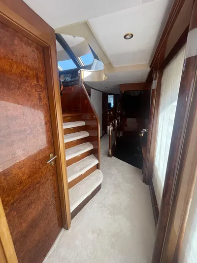 Sarah Sea Yacht Photos Pics Luxurious interior of 2004 Kaiserwerft Baron 102 yacht with wooden finishes and carpeted stairs.