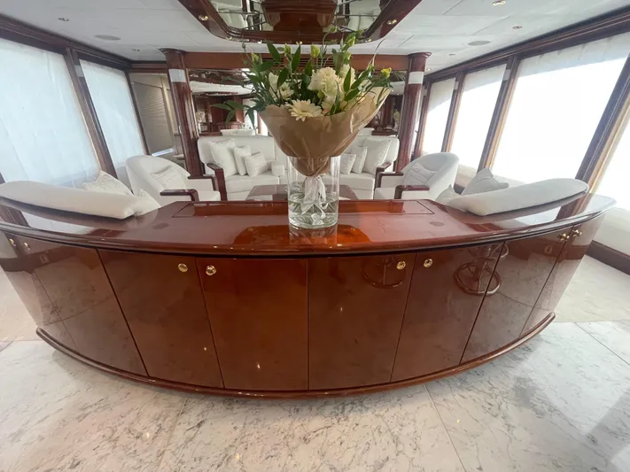 Sarah Sea Yacht Photos Pics Luxurious interior of 2004 Kaiserwerft Baron 102 yacht with elegant wood finish and floral arrangement.