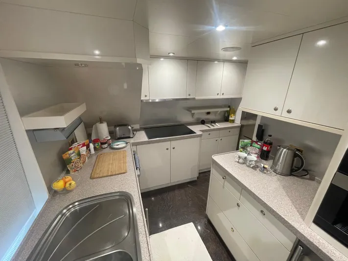 Sarah Sea Yacht Photos Pics Modern kitchen interior on 2004 Kaiserwerft Baron 102 yacht, featuring sleek cabinetry and appliances.