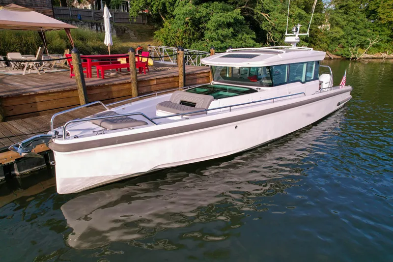 Raven Yacht Photos Pics 2021 Axopar 37 XC CROSS CABIN boat docked by a wooden pier.