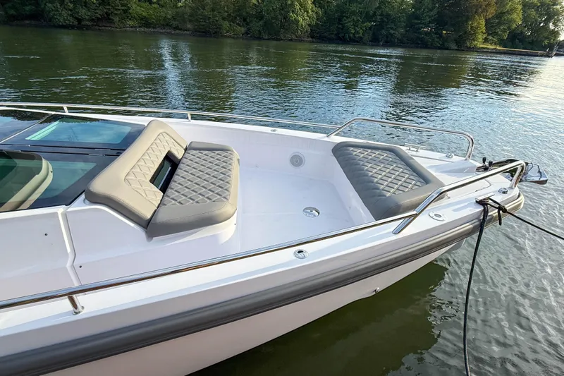 Raven Yacht Photos Pics 2021 Axopar 37 XC CROSS CABIN boat with cushioned seating on calm water.