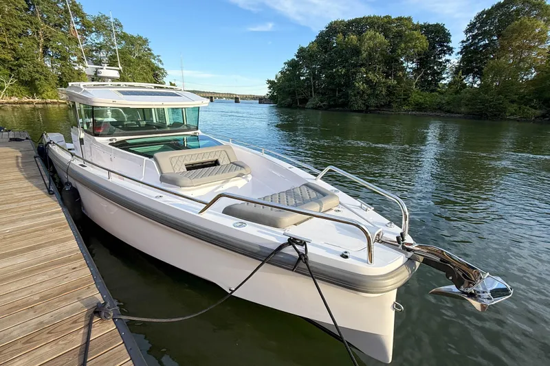 Raven Yacht Photos Pics 2021 Axopar 37 XC CROSS CABIN boat docked on a serene river.