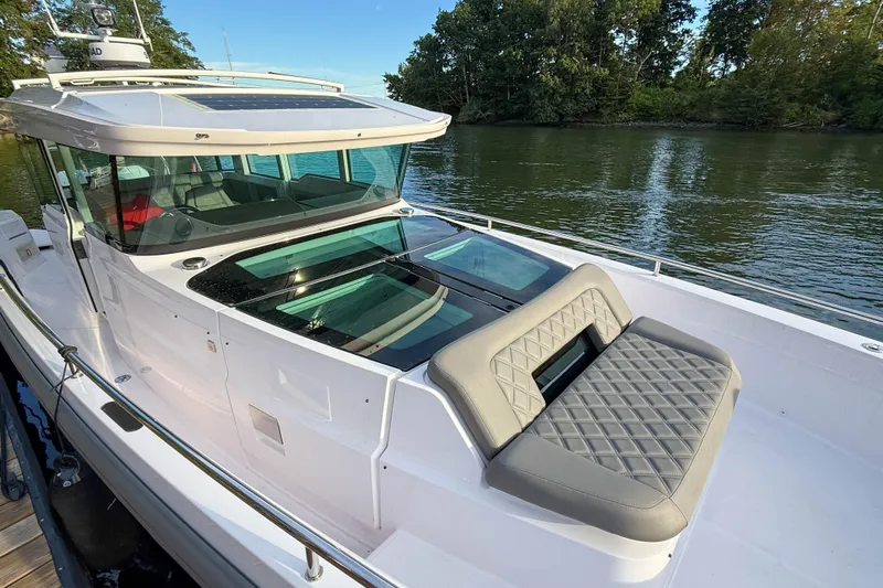Raven Yacht Photos Pics 2021 Axopar 37 XC CROSS CABIN boat with sleek design, docked by a serene river.