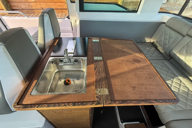 Raven Yacht Photos Pics 2021 Axopar 37 XC CROSS CABIN interior with sink and seating area.