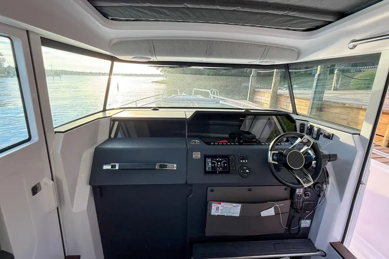 Raven Yacht Photos Pics Interior view of 2021 Axopar 37 XC CROSS CABIN boat cockpit with steering wheel.
