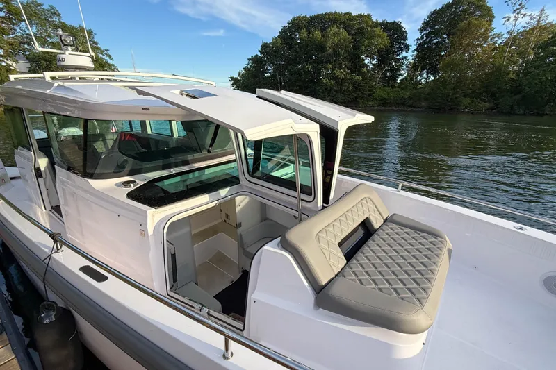Raven Yacht Photos Pics 2021 Axopar 37 XC CROSS CABIN boat docked by a serene river.