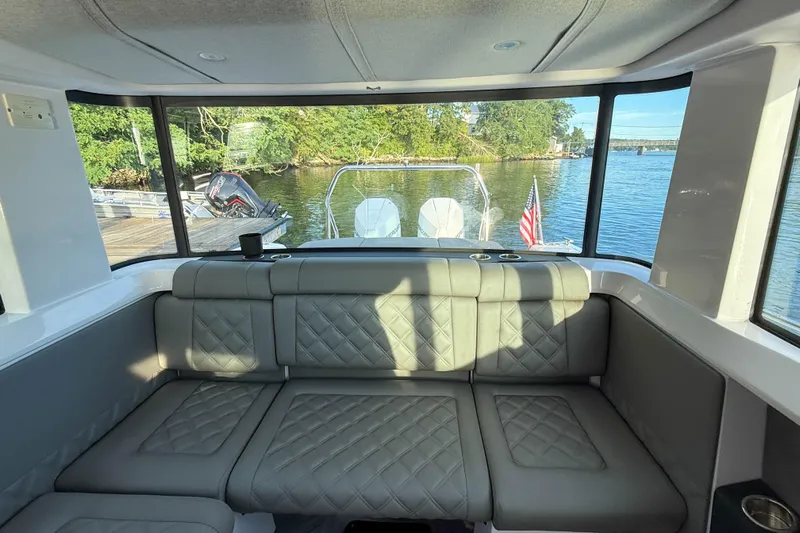 Raven Yacht Photos Pics Interior view of 2021 Axopar 37 XC CROSS CABIN with plush seating and scenic water backdrop.