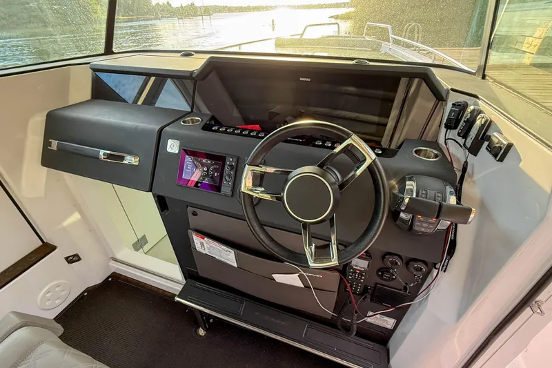 Raven Yacht Photos Pics 2021 Axopar 37 XC CROSS CABIN helm with steering wheel and control panel.