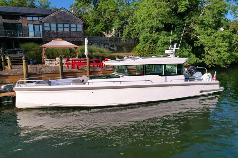 Raven Yacht Photos Pics 2021 Axopar 37 XC CROSS CABIN boat docked by a scenic waterfront home.