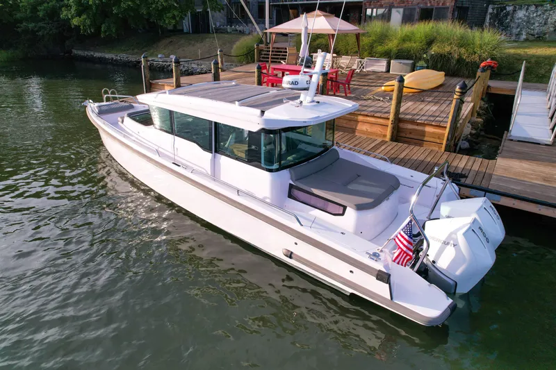 Raven Yacht Photos Pics 2021 Axopar 37 XC CROSS CABIN boat docked by a wooden pier.