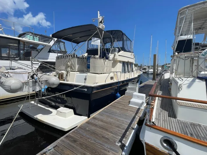 Nowhere Fast Yacht Photos Pics 2005 Mainship 430 Aft Cabin 3SR Trawler docked at marina under clear blue sky.