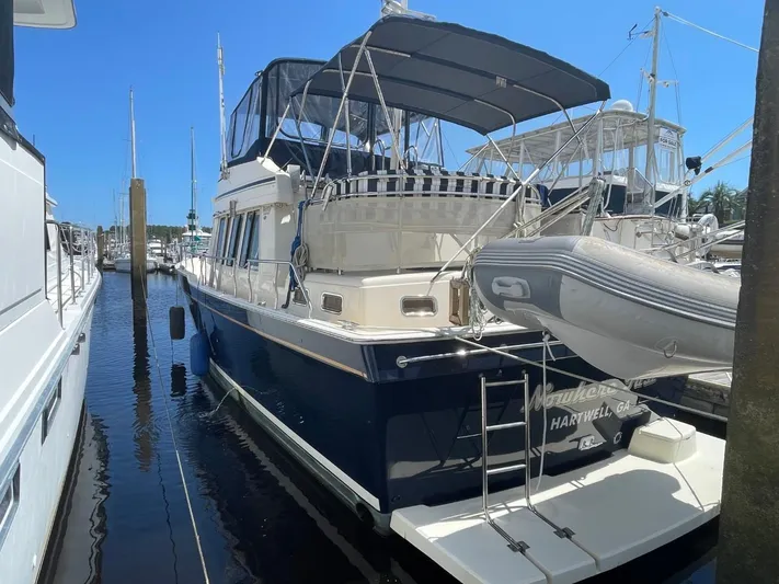 Nowhere Fast Yacht Photos Pics 2005 Mainship 430 Aft Cabin Trawler docked, featuring blue hull and covered deck.