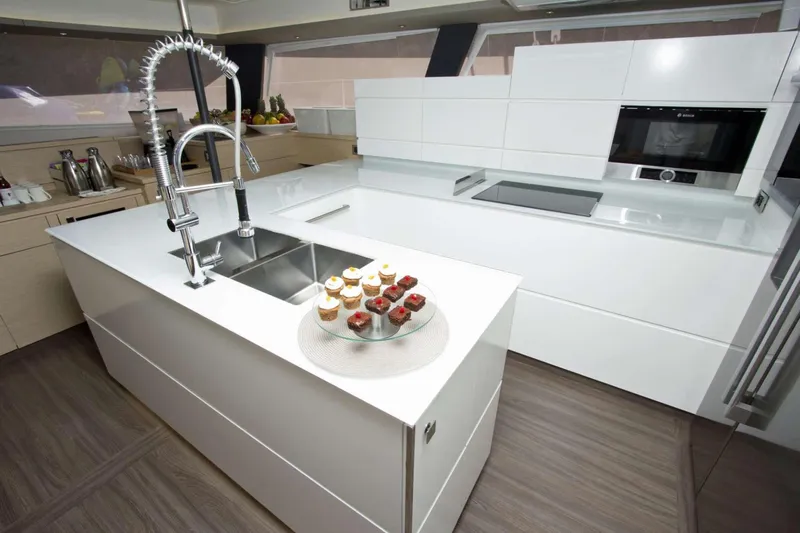Neverland Yacht Photos Pics Modern kitchen interior on 2018 Fountaine Pajot Catamaran 67 with sleek design and cupcakes.