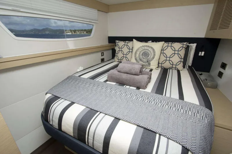 Neverland Yacht Photos Pics Luxurious bedroom interior of 2018 Fountaine Pajot Catamaran 67 with striped bedding.