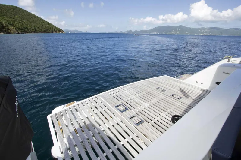 Neverland Yacht Photos Pics Fountaine Pajot Catamaran 67 (2018) deck overlooking serene ocean and lush coastline.