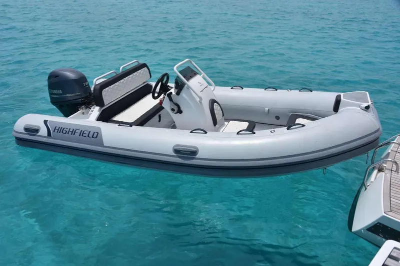 Neverland Yacht Photos Pics Highfield inflatable boat on clear blue water, near Fountaine Pajot Catamaran 67, 2018 model.