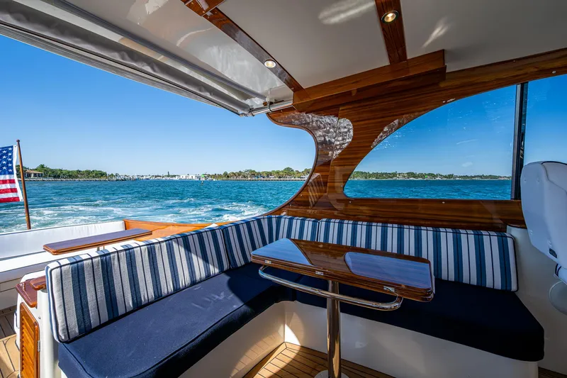  Yacht Photos Pics Hinckley Picnic Boat 40 interior with striped seating, overlooking serene blue waters, 2025 model.