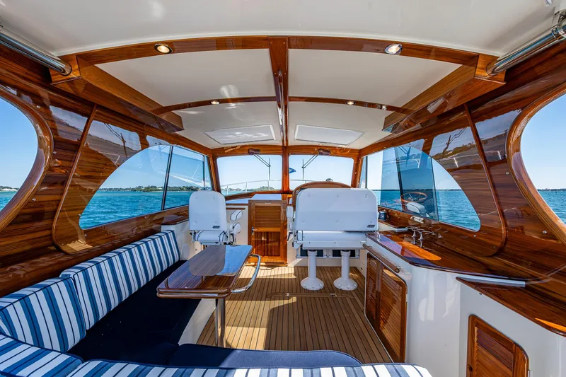  Yacht Photos Pics 2025 Hinckley Picnic Boat 40 interior with striped seating and wooden accents on open water.