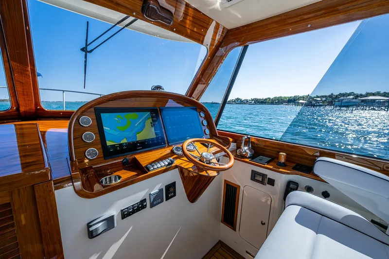 Yacht Photos Pics 2025 Hinckley Picnic Boat 40 cockpit with navigation system, wooden steering, and ocean view.