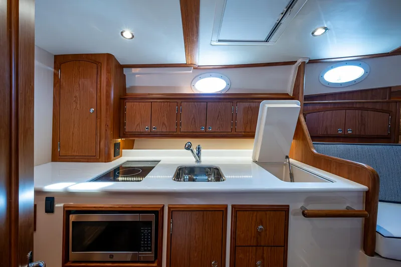  Yacht Photos Pics 2025 Hinckley Picnic Boat 40 interior kitchen with wood cabinetry and modern appliances.
